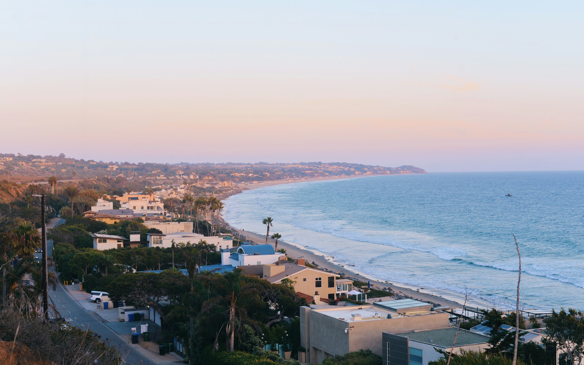 Illustrative Malibu coastline and hillside residences in evening light